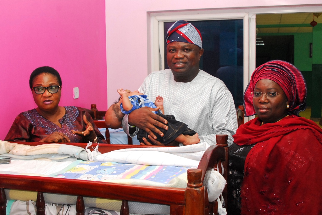 All Progressives Congress (APC) Lagos State Governorship Candidate, Mr. Akinwunmi Ambode with one of the children at the Hearts of Gold Children’s Hospice Surulere Lagos during a visit to the Hospice on New Year's day. With him are the Founder Hearts of Gold Children’s Hospice, Mrs. Lola Adedoyin (left) and Mr. Ambode's running mate and Secretary to the Lagos State Government Mrs. Idiat Oluranti Adebule